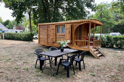 Laverie avec machines à laver, sèche-linge, éviers, miroirs et cabines jaunes dans un espace carrelé.