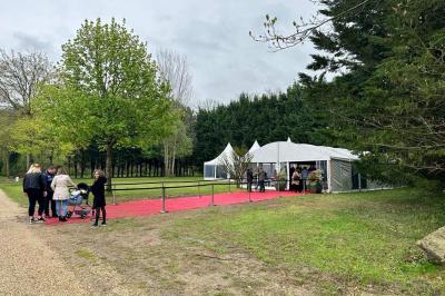 Laverie avec machines à laver, sèche-linge, éviers, miroirs et cabines jaunes dans un espace carrelé.