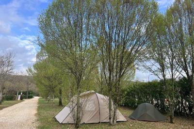 Laverie avec machines à laver, sèche-linge, éviers, miroirs et cabines jaunes dans un espace carrelé.