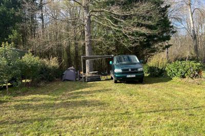 Laverie avec machines à laver, sèche-linge, éviers, miroirs et cabines jaunes dans un espace carrelé.