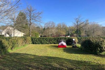 Laverie avec machines à laver, sèche-linge, éviers, miroirs et cabines jaunes dans un espace carrelé.