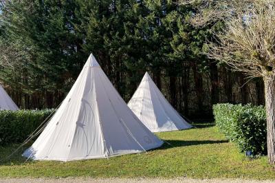Laverie avec machines à laver, sèche-linge, éviers, miroirs et cabines jaunes dans un espace carrelé.