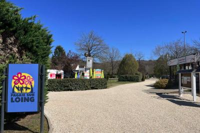 Laverie avec machines à laver, sèche-linge, éviers, miroirs et cabines jaunes dans un espace carrelé.