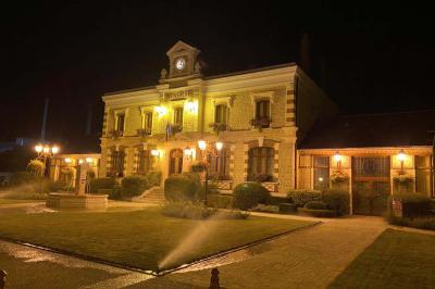 Laverie avec machines à laver, sèche-linge, éviers, miroirs et cabines jaunes dans un espace carrelé.