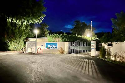 Laverie avec machines à laver, sèche-linge, éviers, miroirs et cabines jaunes dans un espace carrelé.