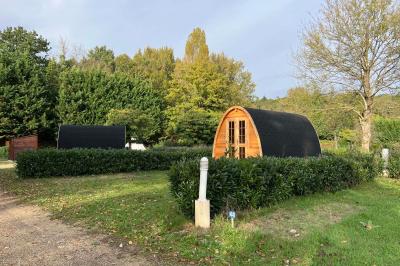 Laverie avec machines à laver, sèche-linge, éviers, miroirs et cabines jaunes dans un espace carrelé.