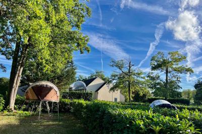 Laverie avec machines à laver, sèche-linge, éviers, miroirs et cabines jaunes dans un espace carrelé.