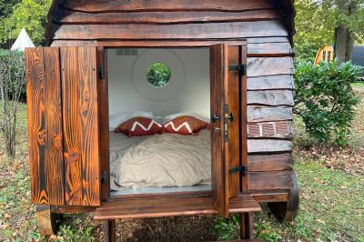 Laverie avec machines à laver, sèche-linge, éviers, miroirs et cabines jaunes dans un espace carrelé.