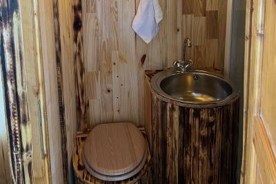 Laverie avec machines à laver, sèche-linge, éviers, miroirs et cabines jaunes dans un espace carrelé.