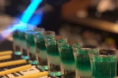 Deux personnes souriantes dans un café à l'ambiance chaleureuse, avec un mur en briques et une enseigne néon.