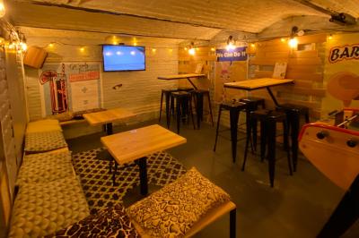 Deux personnes souriantes dans un café à l'ambiance chaleureuse, avec un mur en briques et une enseigne néon.