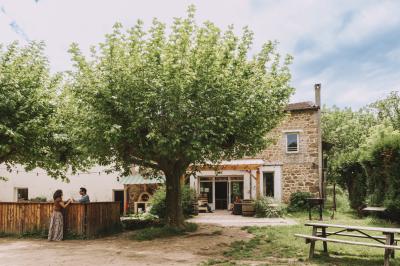 Salon chaleureux avec fauteuils en rotin, canapé, poêle à bois, bibliothèque et lumière naturelle.