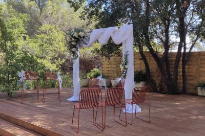 Décoration de table élégante sous un plafond de guirlandes lumineuses et de toile de jute en soirée extérieure.