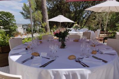Décoration de table élégante sous un plafond de guirlandes lumineuses et de toile de jute en soirée extérieure.