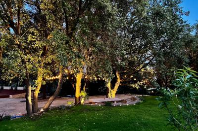 Décoration de table élégante sous un plafond de guirlandes lumineuses et de toile de jute en soirée extérieure.