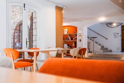 Décoration de table élégante sous un plafond de guirlandes lumineuses et de toile de jute en soirée extérieure.