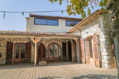 Décoration de table élégante sous un plafond de guirlandes lumineuses et de toile de jute en soirée extérieure.