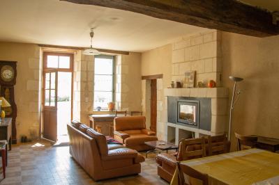 Chambre lumineuse avec un lit double, un canapé, un bureau en bois et une fenêtre donnant sur un espace vert.
