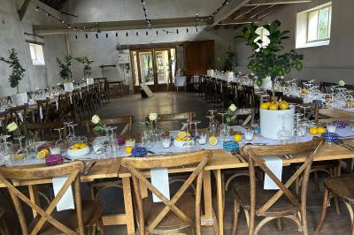 Chambre lumineuse avec un lit double, un canapé, un bureau en bois et une fenêtre donnant sur un espace vert.