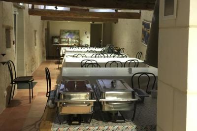 Chambre lumineuse avec un lit double, un canapé, un bureau en bois et une fenêtre donnant sur un espace vert.