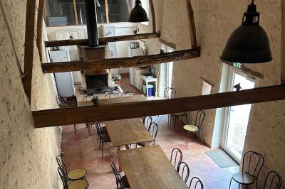 Chambre lumineuse avec un lit double, un canapé, un bureau en bois et une fenêtre donnant sur un espace vert.