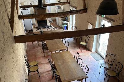 Chambre lumineuse avec un lit double, un canapé, un bureau en bois et une fenêtre donnant sur un espace vert.