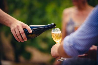 Village entouré de vignes et de collines verdoyantes sous un ciel partiellement nuageux.