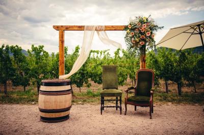 Village entouré de vignes et de collines verdoyantes sous un ciel partiellement nuageux.