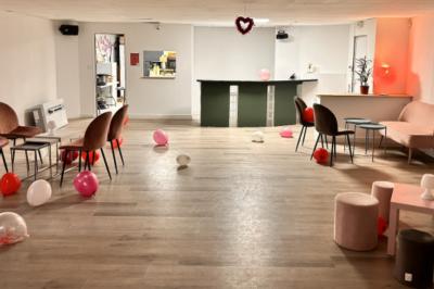 Arbre décoratif avec branches noires ornées de fleurs artificielles et de petites décorations suspendues.