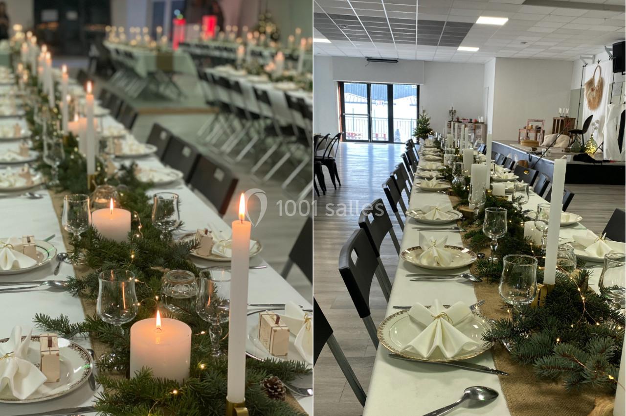 Tables décorées pour un repas festif, ornées de bougies, branches de sapin et serviettes pliées, dans une grande salle…