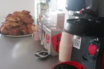 Arbre décoratif avec branches noires ornées de fleurs artificielles et de petites décorations suspendues.