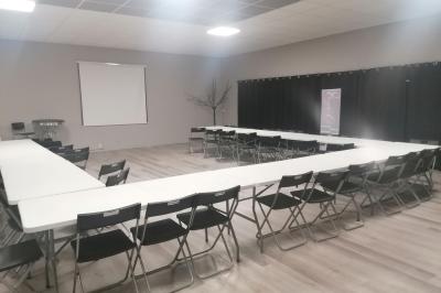 Arbre décoratif avec branches noires ornées de fleurs artificielles et de petites décorations suspendues.