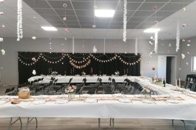 Arbre décoratif avec branches noires ornées de fleurs artificielles et de petites décorations suspendues.