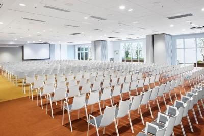 Espace de coworking lumineux avec canapé, étagères, plantes, et coin café équipé dans un décor moderne.