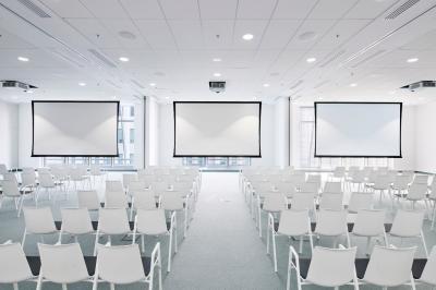 Espace de coworking lumineux avec canapé, étagères, plantes, et coin café équipé dans un décor moderne.