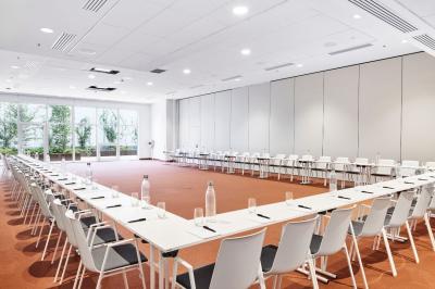 Espace de coworking lumineux avec canapé, étagères, plantes, et coin café équipé dans un décor moderne.