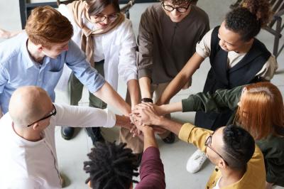 Deux personnes en tenue professionnelle discutant, avec des mots-clés flottants comme ’idée’ et ’travail’ sur fond bleu.