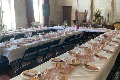 Plaque en pierre gravée avec des inscriptions dorées et un motif de croix ailée au-dessus du texte.