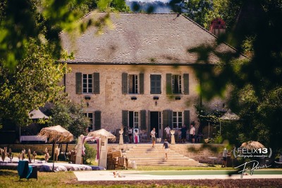 Plaque en pierre gravée avec des inscriptions dorées et un motif de croix ailée au-dessus du texte.