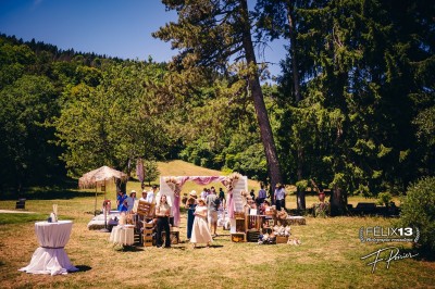 Plaque en pierre gravée avec des inscriptions dorées et un motif de croix ailée au-dessus du texte.