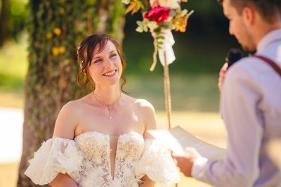 Plaque en pierre gravée avec des inscriptions dorées et un motif de croix ailée au-dessus du texte.