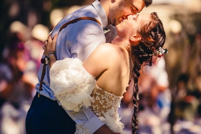 Plaque en pierre gravée avec des inscriptions dorées et un motif de croix ailée au-dessus du texte.