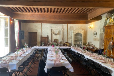 Plaque en pierre gravée avec des inscriptions dorées et un motif de croix ailée au-dessus du texte.
