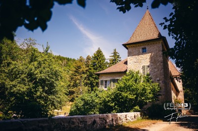 Plaque en pierre gravée avec des inscriptions dorées et un motif de croix ailée au-dessus du texte.