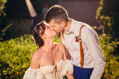 Plaque en pierre gravée avec des inscriptions dorées et un motif de croix ailée au-dessus du texte.