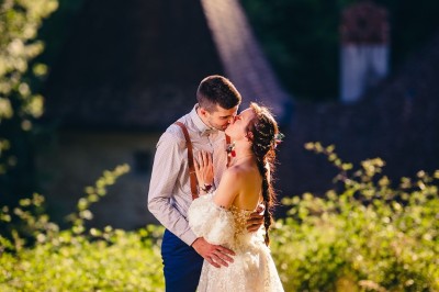 Plaque en pierre gravée avec des inscriptions dorées et un motif de croix ailée au-dessus du texte.