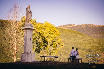 Plaque en pierre gravée avec des inscriptions dorées et un motif de croix ailée au-dessus du texte.