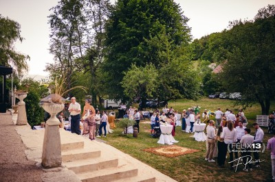 Plaque en pierre gravée avec des inscriptions dorées et un motif de croix ailée au-dessus du texte.