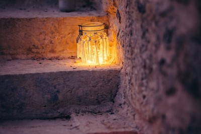 Plaque en pierre gravée avec des inscriptions dorées et un motif de croix ailée au-dessus du texte.