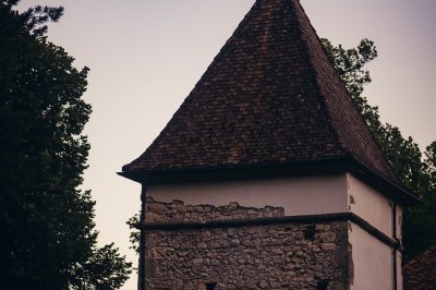 Plaque en pierre gravée avec des inscriptions dorées et un motif de croix ailée au-dessus du texte.